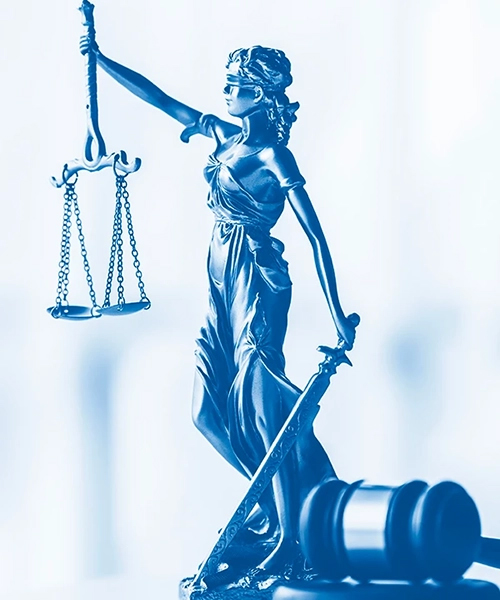 Photograph with blue filter of the goddess Themis, holding a scale with her right hand and a sword with her left hand; there is also a gavel